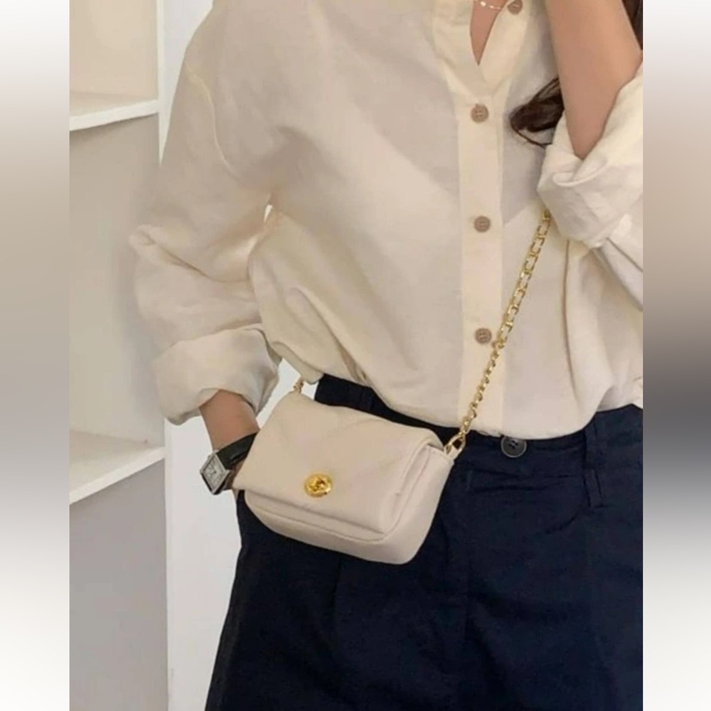 Quilted crossbody bag with gold chain.